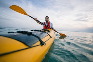 Low angle view of man paddling kayak.