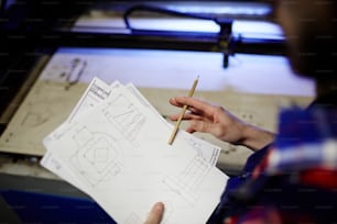 Technical sketches in hand of modern young engineer
