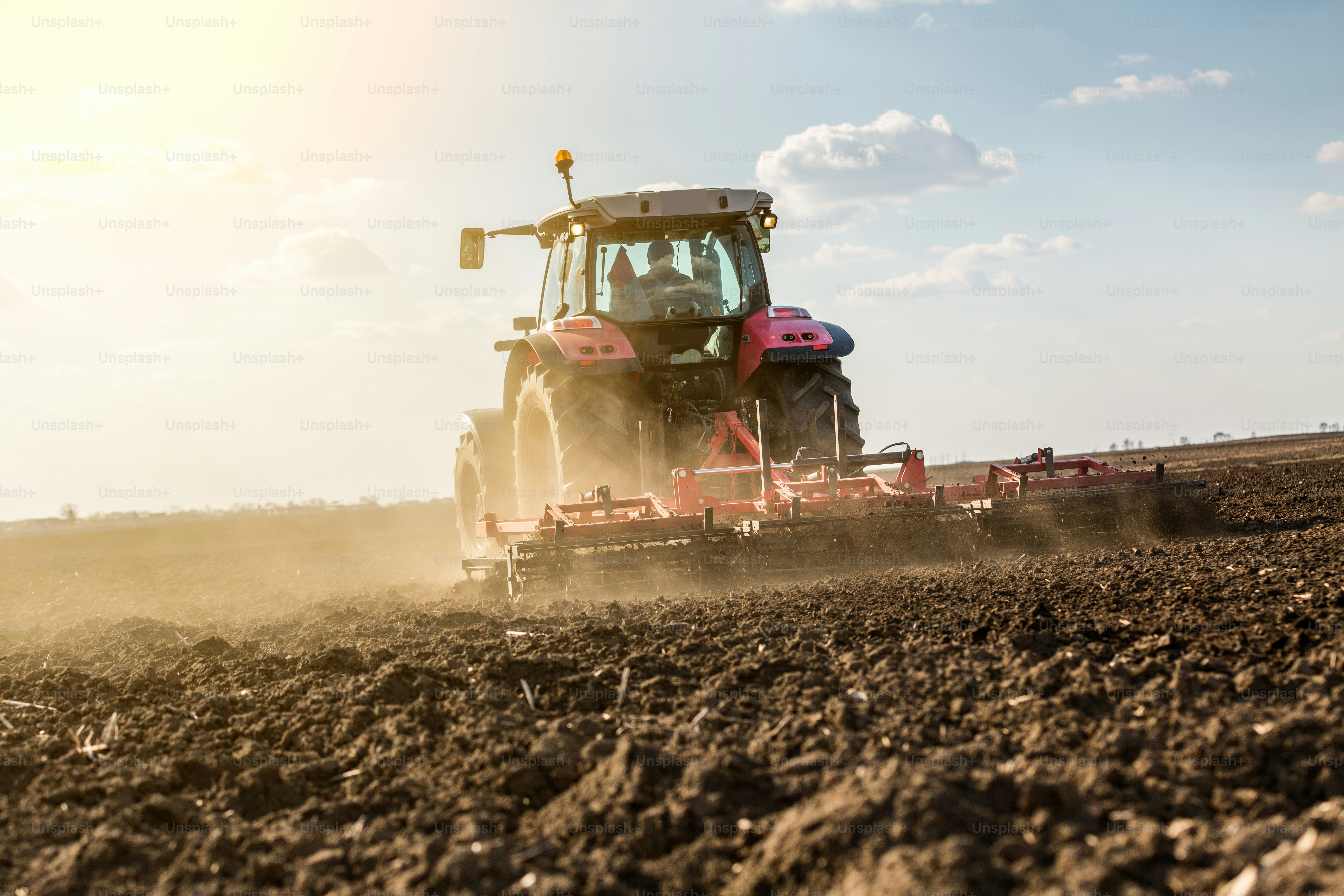 Farmer in tractor preparing land with seedbed cultivator