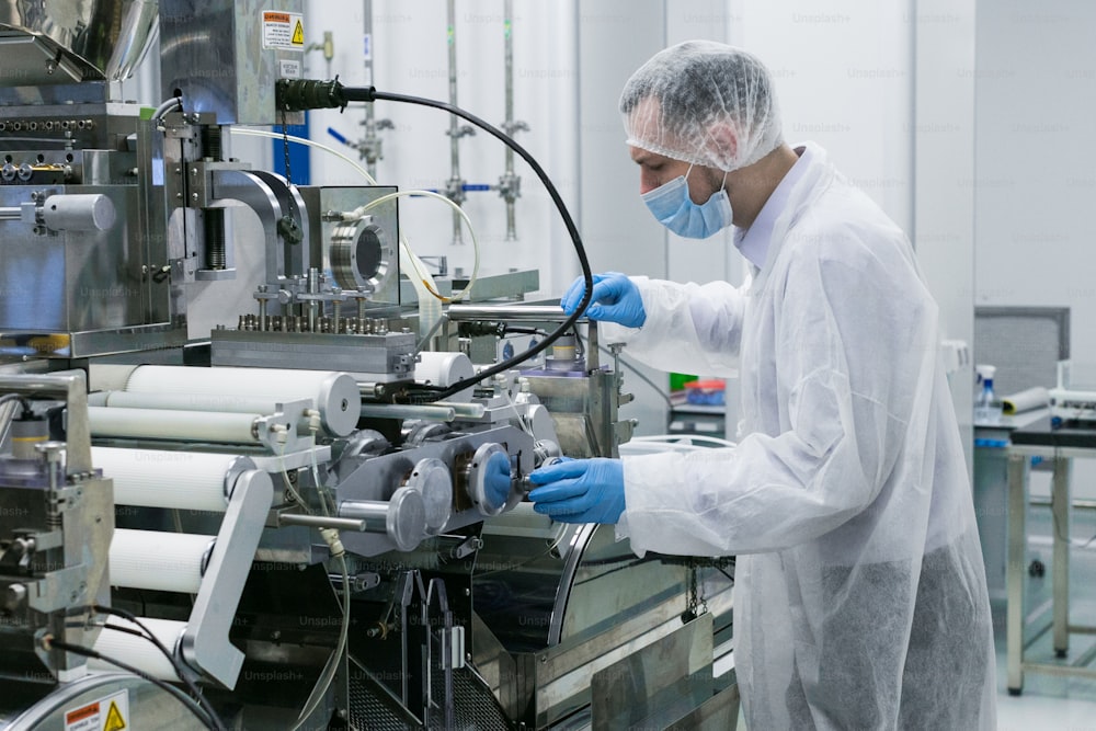 caucasian scientist man work with manufacture machine with shafts