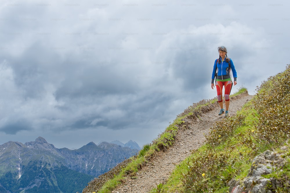 Girl mountain trail walks alone in the summer