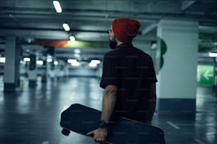 Skater with longboard posing in underground garage.