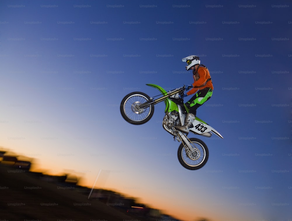a man flying through the air while riding a motorcycle