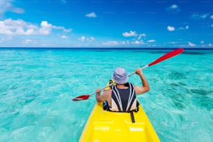 Jeune homme caucasien faisant du kayak en mer aux Maldives