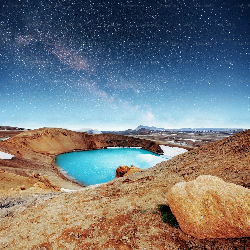 Le volcan géant surplombe. La turquoise fournit une eau géothermale chaude. Fantastique Voie lactée. Pluie de météores Islande