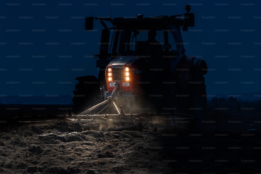 Tracteur préparant la terre pour l’ensemencement de nuit