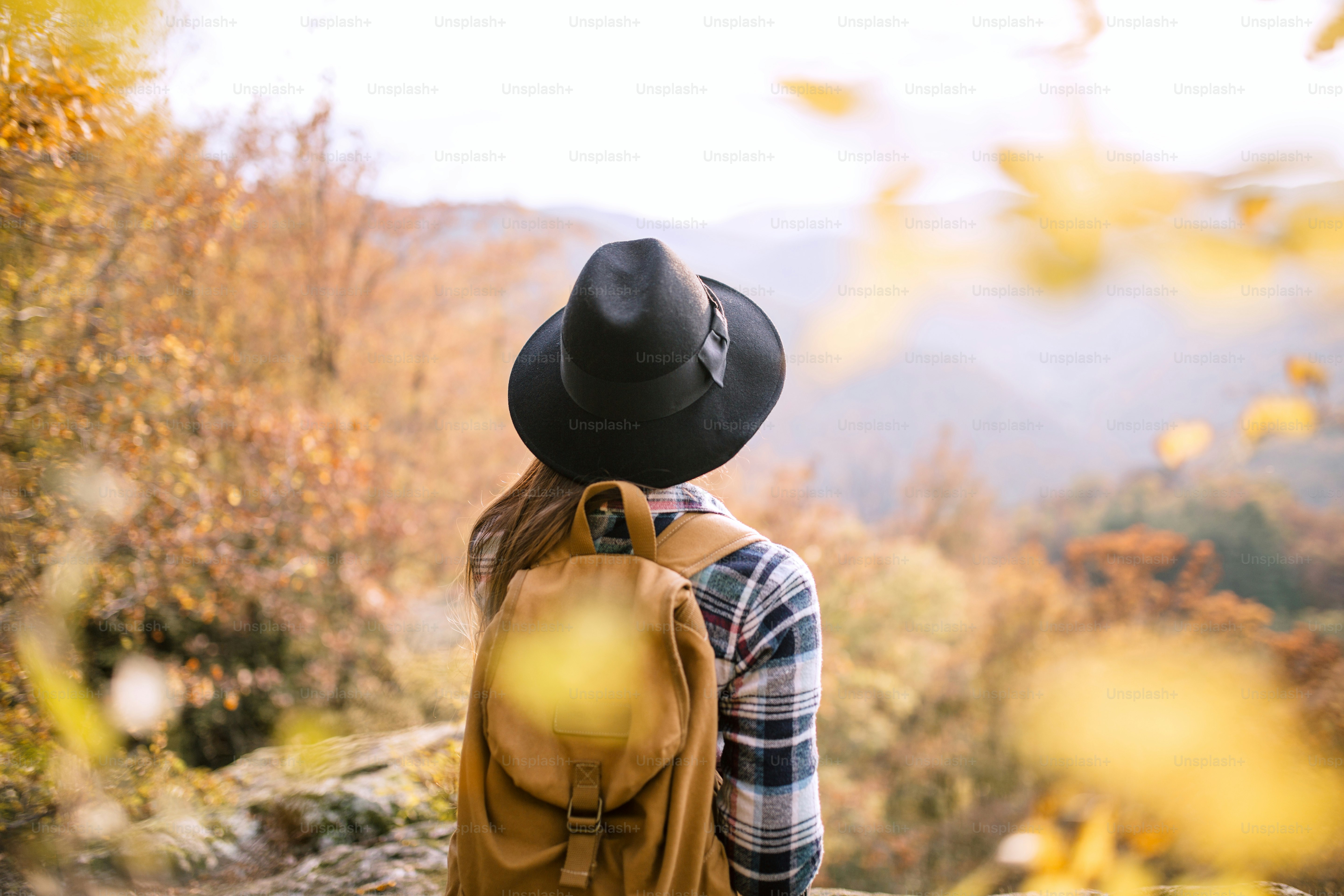 Hipster girl with backpack in forest.