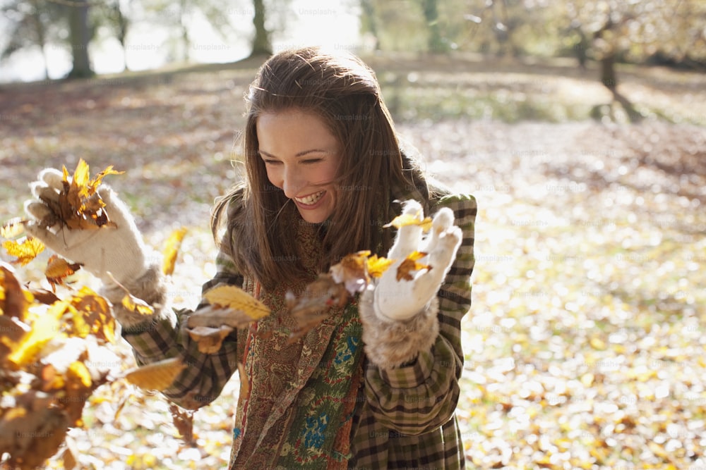 Una mujer sosteniendo hojas en sus manos