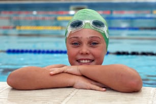 a young girl wearing a swimming cap and goggles