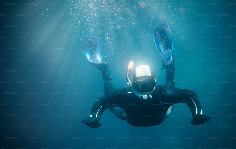 Mergulhador livre debaixo d'água, mergulho com snorkel equilíbrio debaixo d'água.