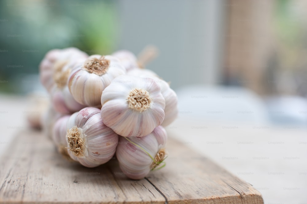 a pile of garlic sitting on top of a wooden table
