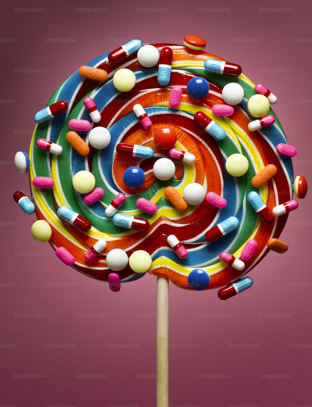 a colorful candy lollipop on top of a wooden stick