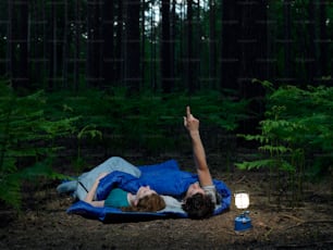 a person laying on a blanket in the woods