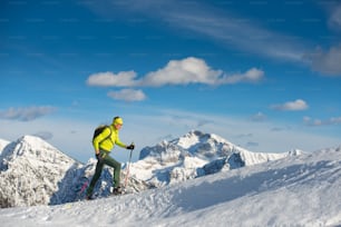 Homem snowshoeing no local da montanha