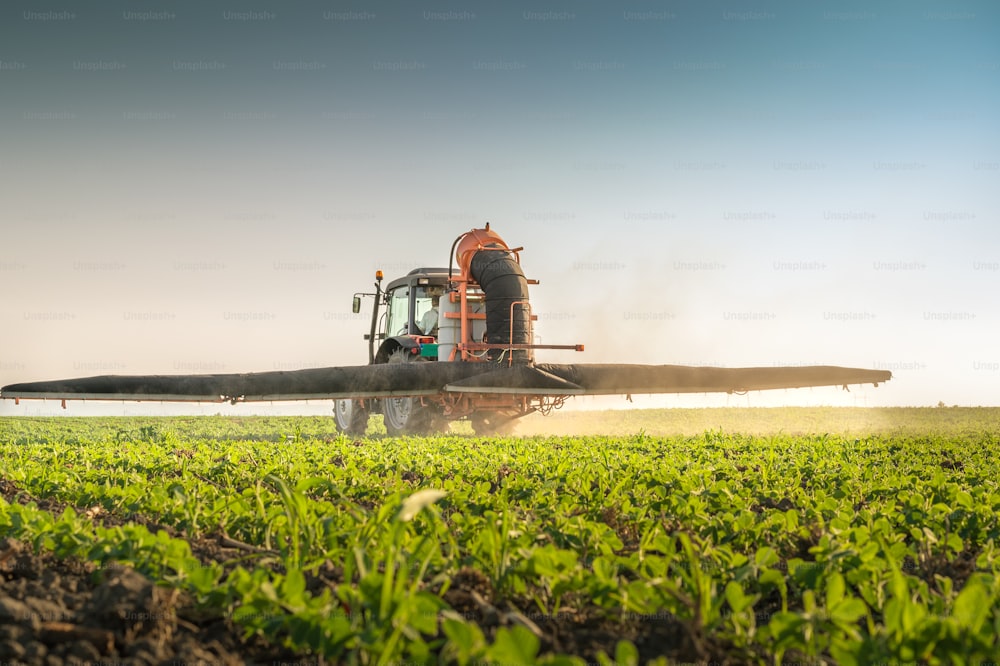 tracteur pulvérisant des pesticides sur le soja