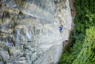 Männlicher Kletterer. Kletterer klettert auf eine Felswand.