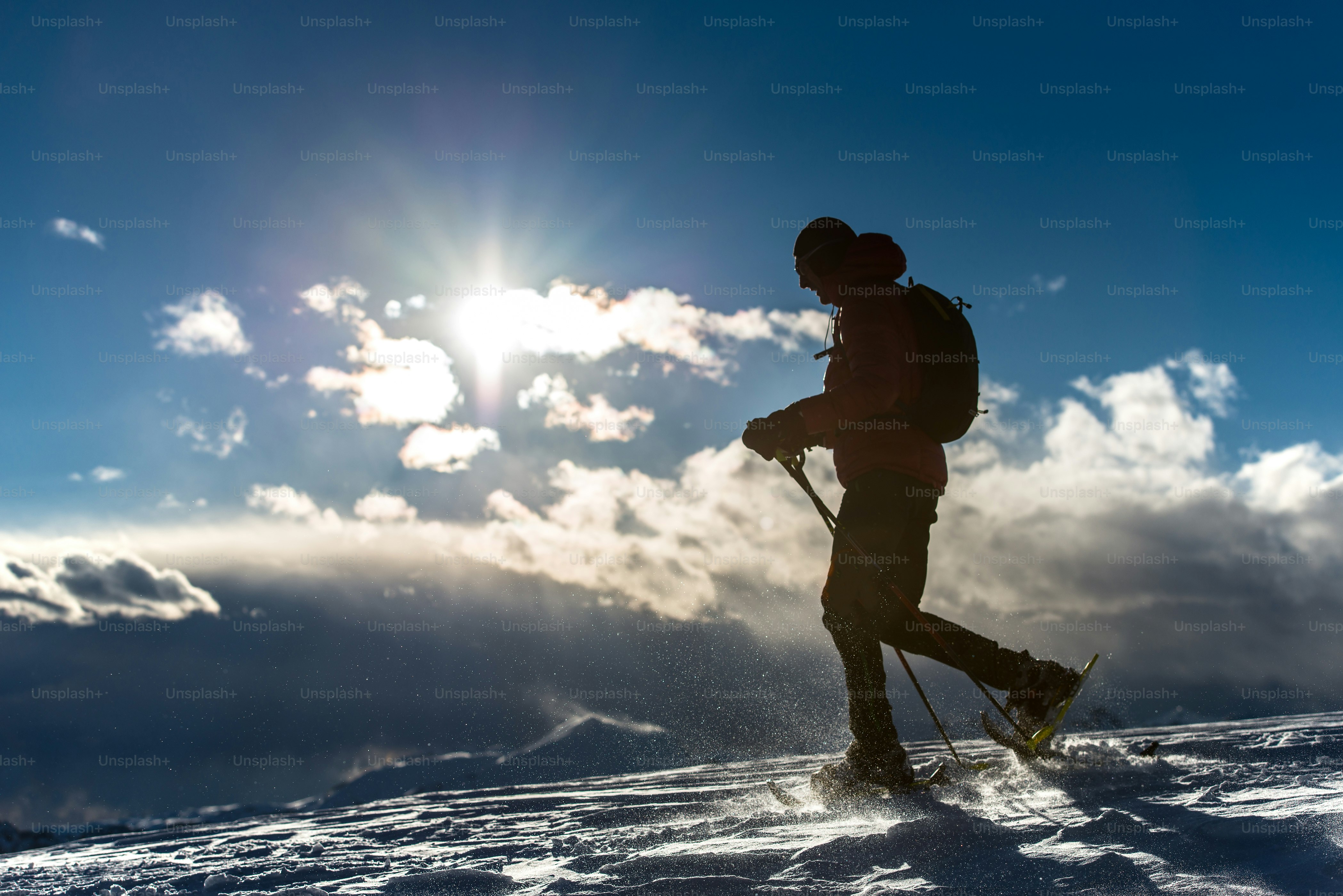 Mann im Schnee mit Schneeschuhen in einer Berglandschaft
