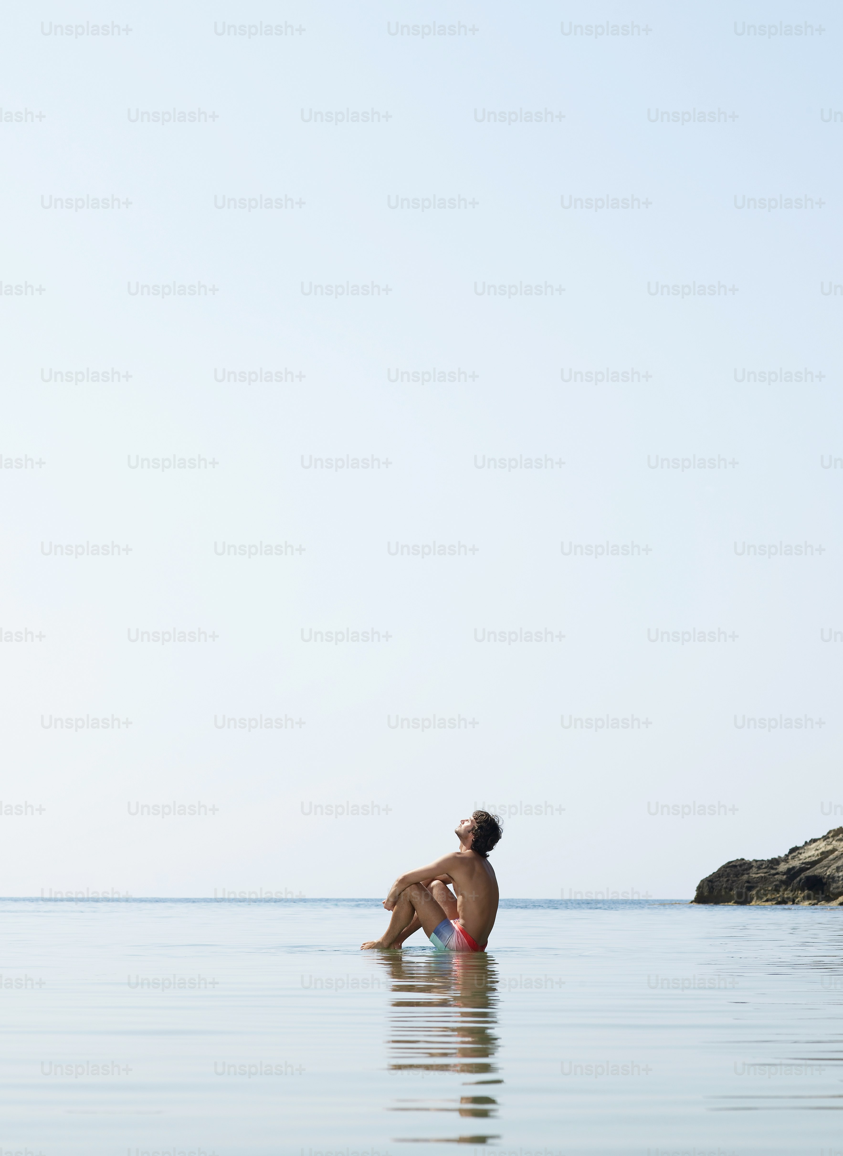 a man sitting on a surfboard in the ocean