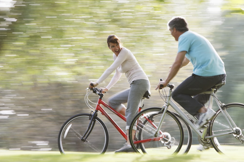 a man and a woman riding bikes in a park