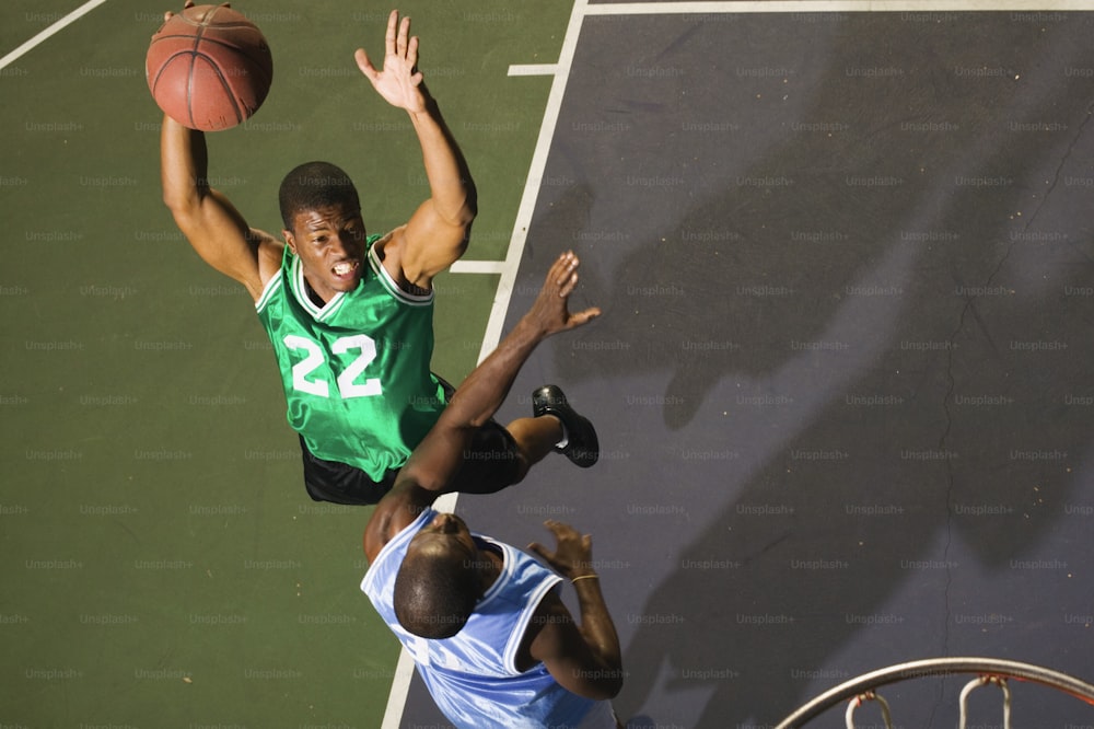 two men playing basketball on a basketball court