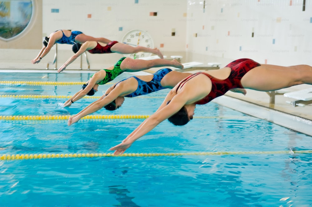 a group of people diving into a swimming pool