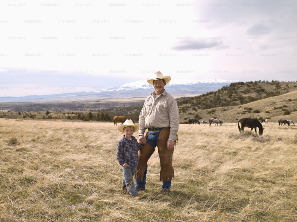 Father and son on range in Big Timber, Montana checking horses health on ranch 