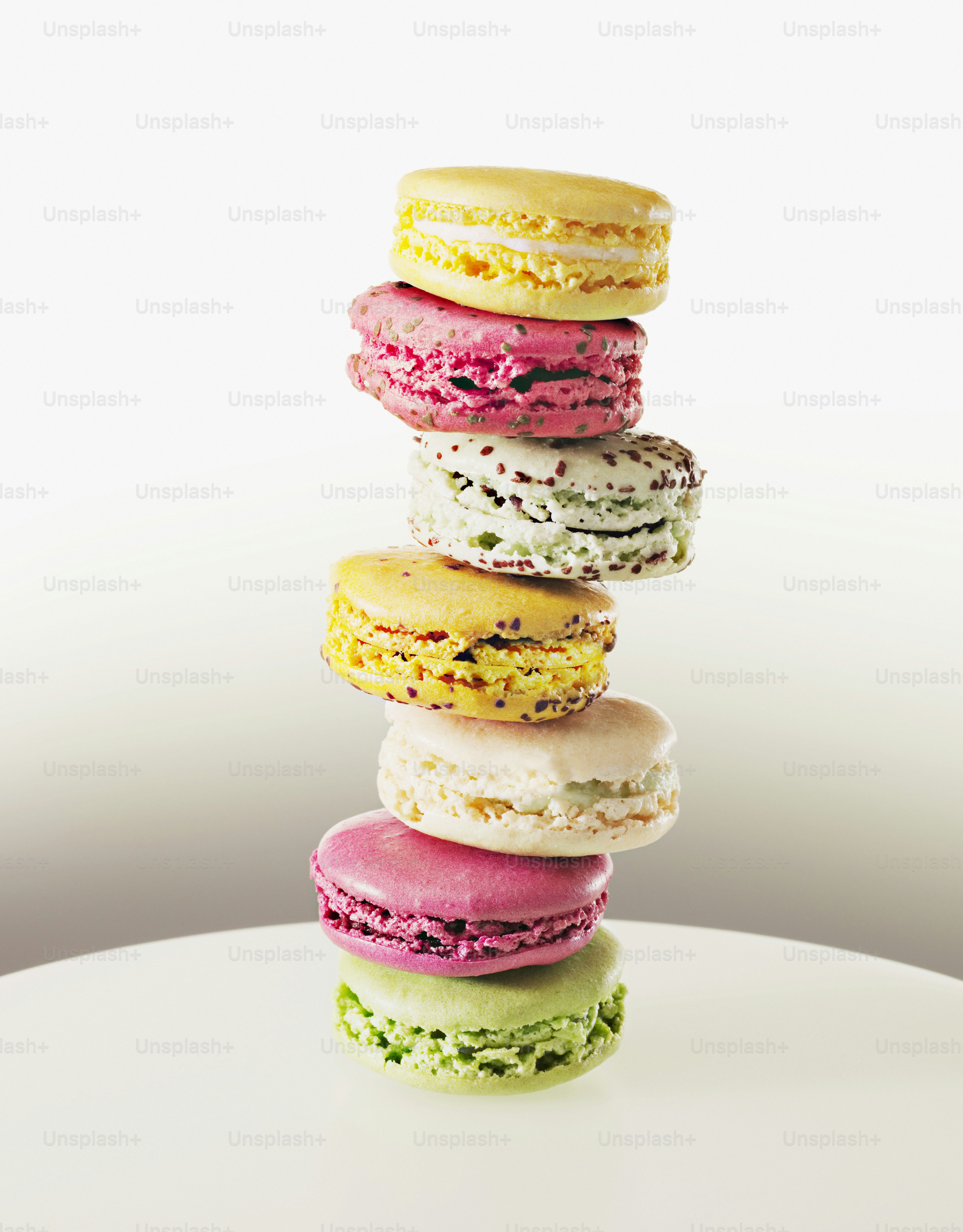 A stack of macaroons sitting on top of a white table photo – White ...