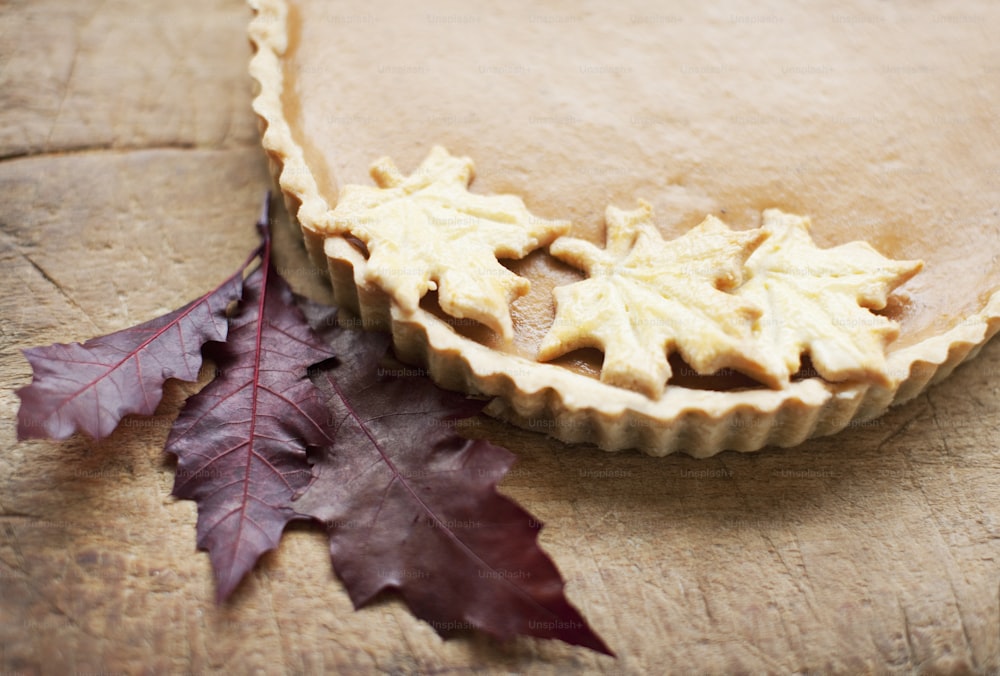 a maple leaf and a pie crust on a piece of wood