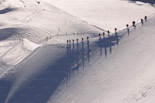 a group of people walking up the side of a snow covered slope