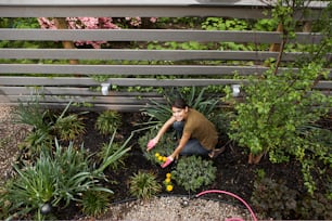 a person kneeling down in a garden with plants