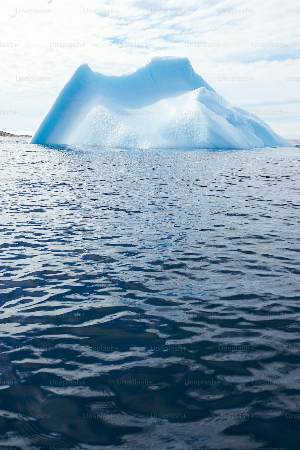 un grand iceberg flottant au-dessus d’un plan d’eau