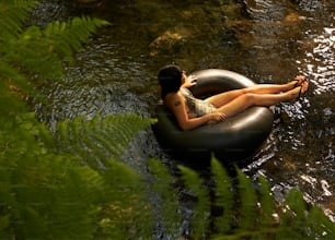 Una mujer acostada en un tubo inflable en un río