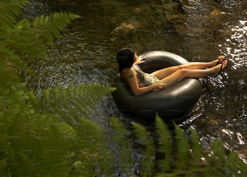 a woman laying on an inflatable tube in a river