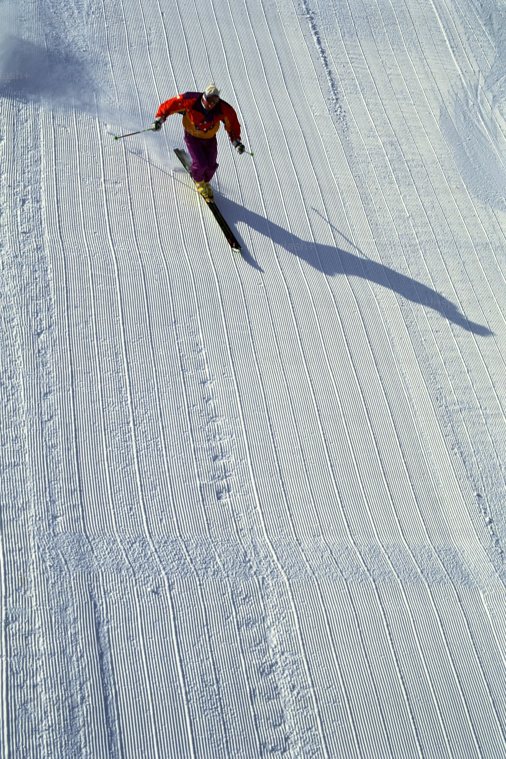 雪に覆われた斜面をスキーで下る人