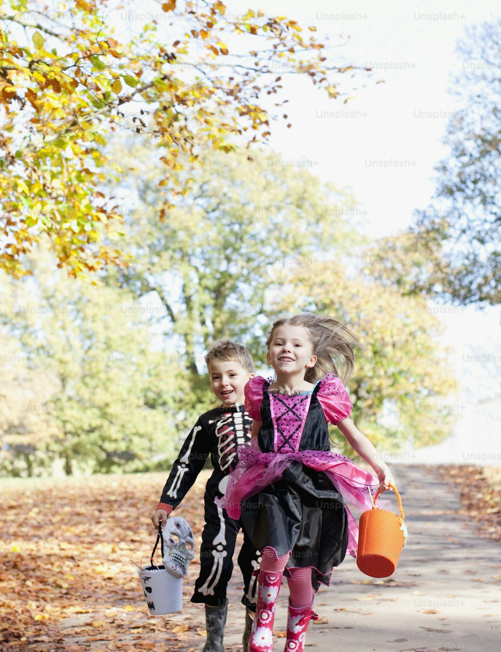two little girls walking down a path in the fall