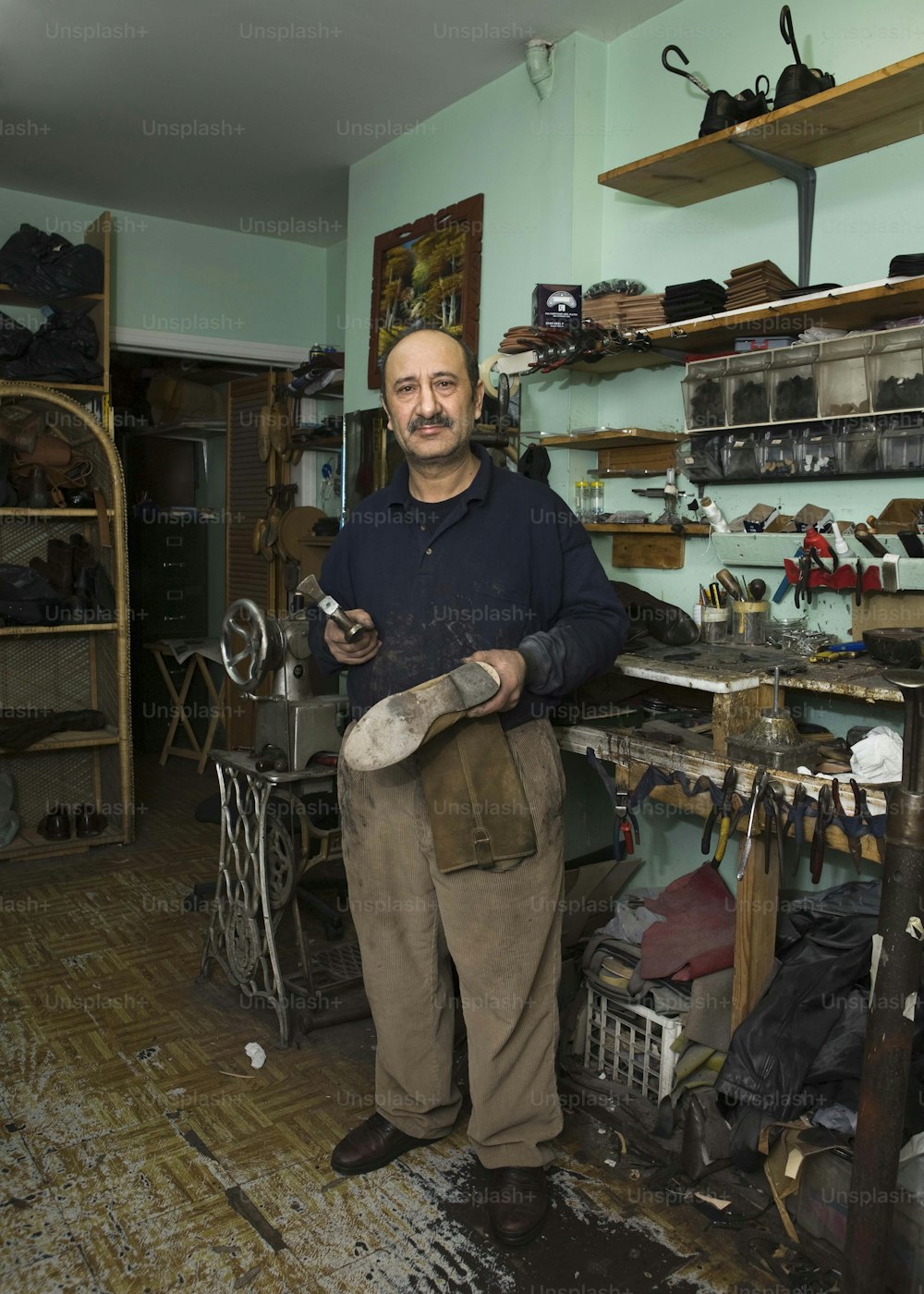 a man standing in a shop holding a shoe