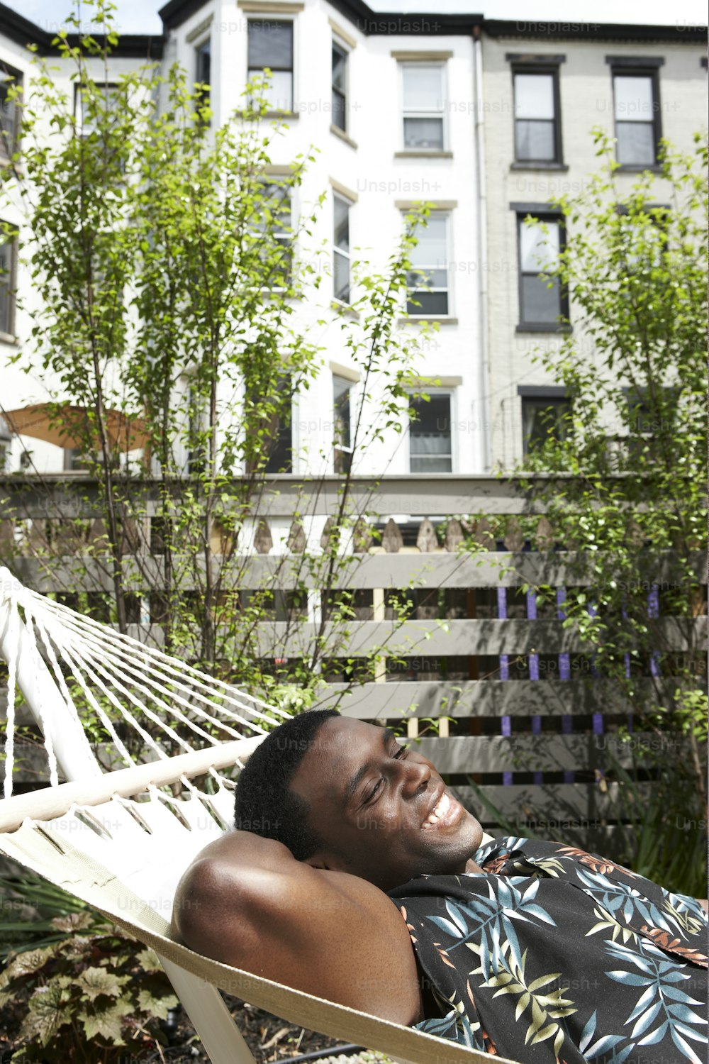 a man laying in a hammock in a yard