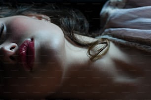 Una mujer acostada en una cama con los ojos cerrados