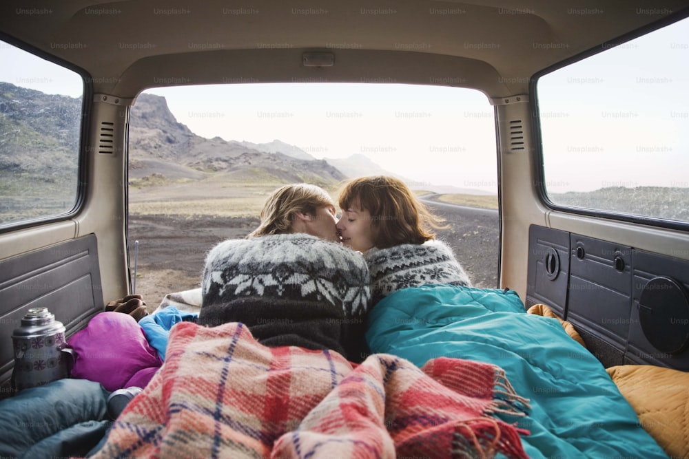 a couple of people laying in the back of a truck