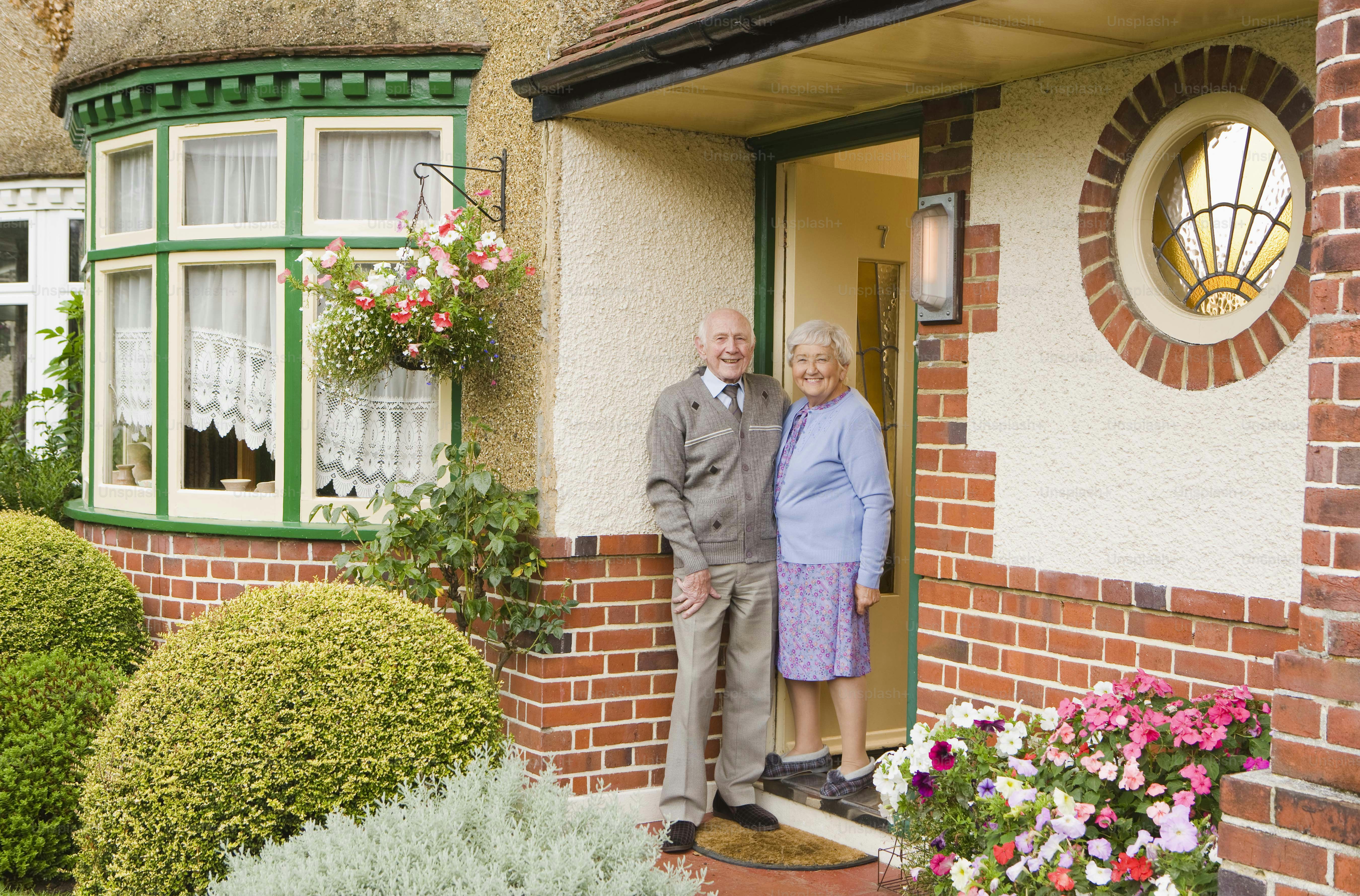 un homme et une femme debout devant une maison