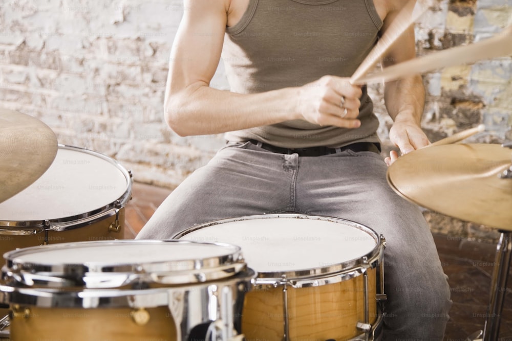 a man sitting on a stool playing drums