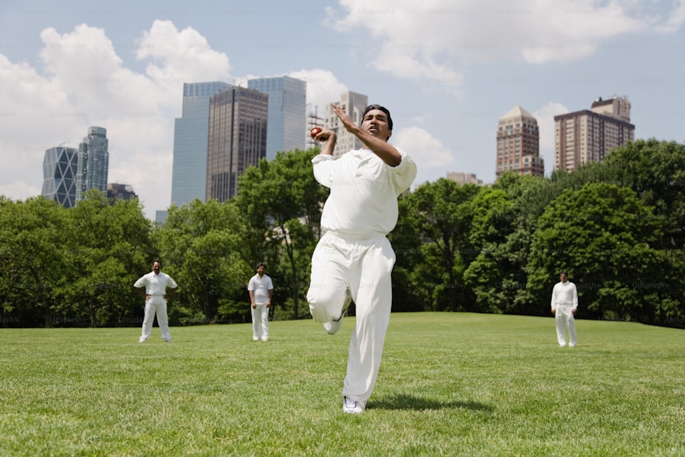a group of men in white playing a game of cricket