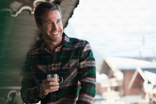 a smiling man holding a glass of beer