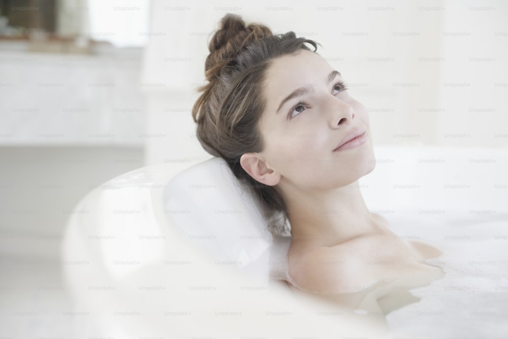 a woman in a bathtub with her eyes closed