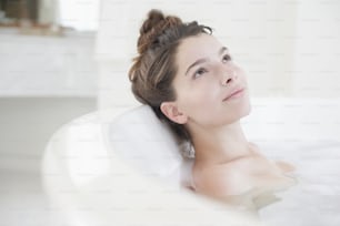 a woman in a bathtub with her eyes closed