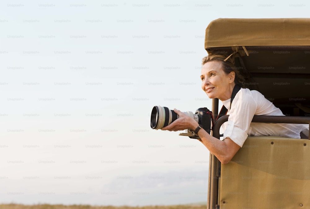 a woman taking a picture of herself in a safari vehicle