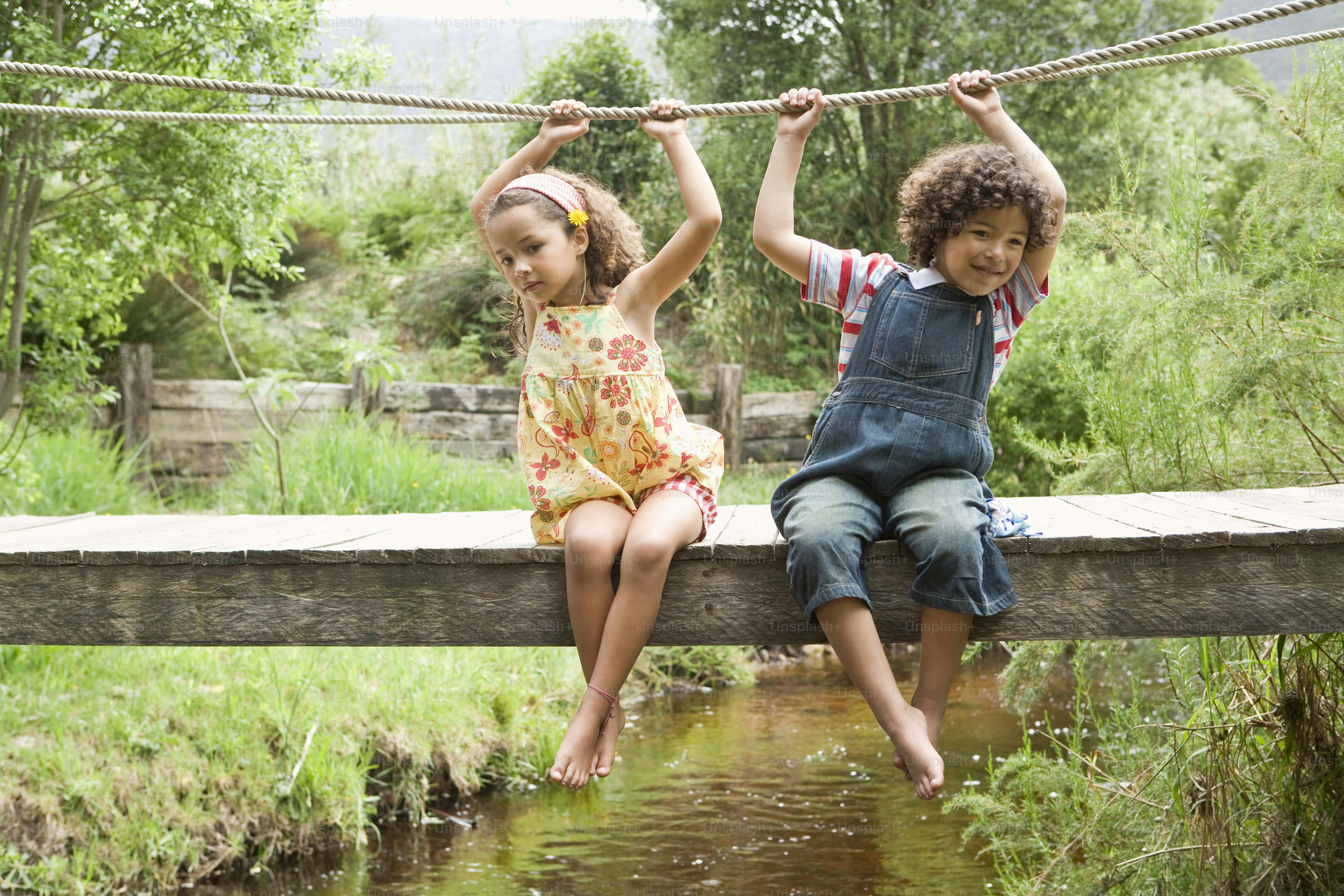 A couple of kids walking across a wooden bridge photo – Forest Image on ...