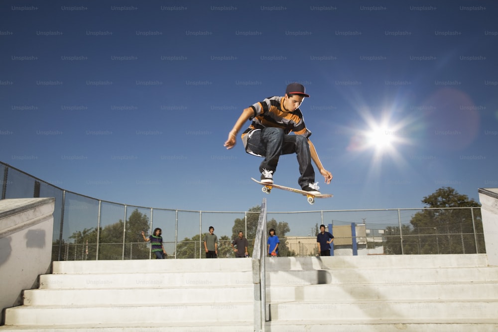 Un uomo che cavalca uno skateboard sul lato di una ringhiera di metallo