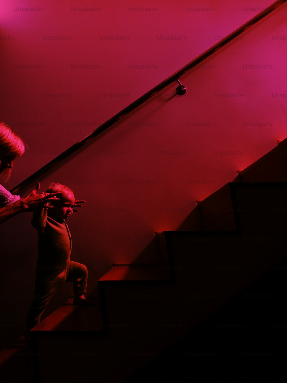 Una mujer ayudando a un niño a subir las escaleras