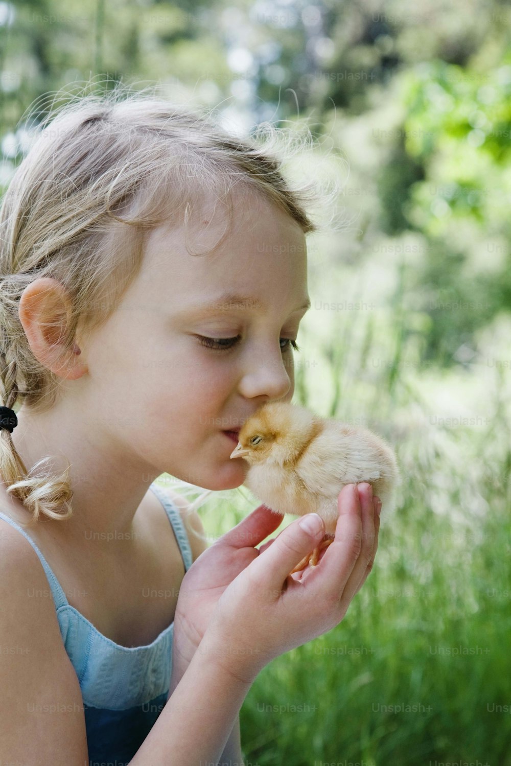 a little girl holding a chicken in her hands